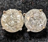 Close-up front view of diamond stud earrings on black background