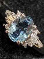 Close front view showing oval blue topaz center and surrounding diamond accents