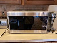Front view of the Panasonic microwave oven showing the full door and stainless steel finish.
