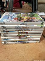 Stack of eight Nintendo Wii game cases showing titles on the spines.