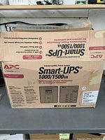 Original cardboard box of APC Smart-UPS showing model and key features.