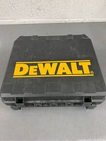 Closed plastic carrying case with large yellow DEWALT logo on top.