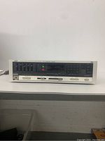 Front view of JVC R-X300 stereo receiver showing control panel with equalizer sliders, buttons, and digital display.