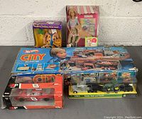 Overview of all toys in the lot including Hot Wheels City playset, Barbie doll, Flintstones Fred figure, NASCAR car, and John Deere tractor set.