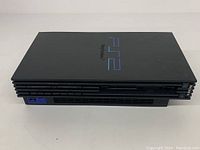 Top view of black Sony Playstation 2 console showing PS2 logo and surface