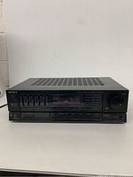 Front view of the Sony audio/video control receiver showing power button, display, sliders, and knob.