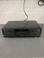 Front angle view showing the full Technics cassette deck with both tape compartments visible.