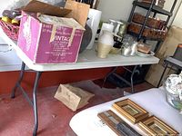 Full side view of folding table with plastic top, showing items on top and under the table.