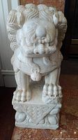 Front view of full marble foo dog statue showing figure and pedestal