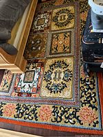 Photo showing corner of the wool rug by a wooden bed frame and luggage, depicting the design and size in room context.
