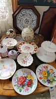 Full lot display on wooden serve tray with visible decorative plates, biscuit jar, milk glass server, candy dishes, and cream and sugar set