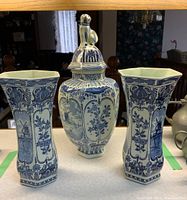 Front view of the pair of Delfts Blau vases with matching ginger jar displayed on a table.