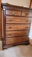 Front view of the five drawer wood highboy dresser showing all drawers and brass handles.