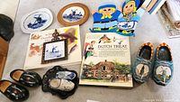 Overview photo of all items, showing books, plates, wooden shoes, oven mitts, and trivet.