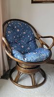 Papasan chair with blue floral cushion, showing overall condition and full view