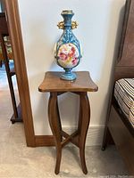 Full view of the wooden accent table with the blue floral urn on top
