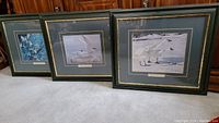 Three framed and matted Robert Bateman prints arranged side by side on floor, showing the overall lot contents.