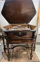 Open wooden octagonal table showing Atwater Kent radio components inside under raised lid.