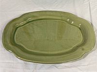 Top-down view of the green glazed oval platter showing its shape, size, and glossy finish.