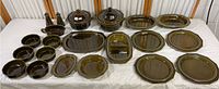 Full lot laid out showing dinnerware pieces including plates, bowls, platters, lidded casserole pots, and salt and pepper shakers in Heritage Green line with dark glossy green glaze.