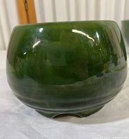 Front side view of the green glazed ceramic planter bowl showing smooth glossy finish.