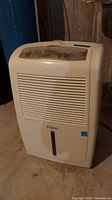 Front view of white Haier dehumidifier showing vent grille and water level window.
