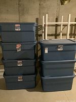 Seven blue Sterilite plastic storage bins stacked, showing general appearance.