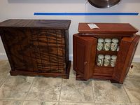 Two wooden spice cabinets side by side on floor, showing different wood finishes and styles.