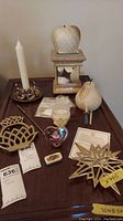 Overview of all items: apple candle on mirrored stand, cream pear candle, swan candle holder, heart photo frame, two metal trivets, small candle snuffer, and tags