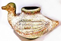 Antique clay bird side view showing carved wing details and hollow opening on top