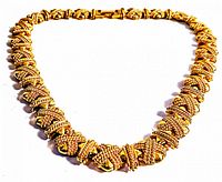 Close-up front view of the heavy vintage gold plated necklace showing intricate woven and beaded pattern links with horizontal band accents and a clasp.