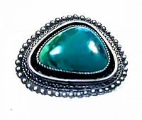 Front view of vintage sterling silver and malachite brooch highlighting the triangular malachite stone with silver bead detailing around the edge.