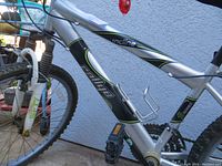 Side view of the silver Rallye Incline mountain bike showing frame, pedals and front suspension
