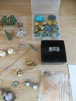Top view of mixed earrings, pins, loose turquoise and gold flake stones