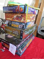 Stack of board games with Air Swimmers Flying Goldfish box on top, Harry Potter Scene It? and Trivial Pursuit visible