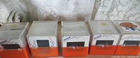 Five sealed boxes of 1980s photo slides in orange and clear plastic holders, some handwritten labeling visible.