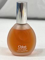 Front view of 1-ounce Chloé Eau de Toilette spray bottle showing label with brand and product details with silver cap.