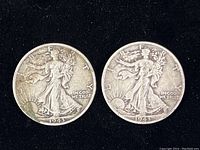 Obverse view of two 1943 Walking Liberty half dollar coins showing Lady Liberty walking with sun rays in the background. Clear date and 'LIBERTY' inscription visible.