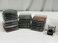 Array of Cokin photographic filters in black protective plastic cases arranged in three stacks. Each case labeled with filter type and series letters/numbers. Small original boxed Canon Flash Coupler D in front.