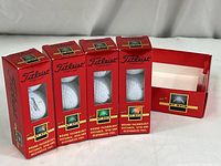 Four 2-pack boxes of Titleist DT Spin golf balls and a red display box.