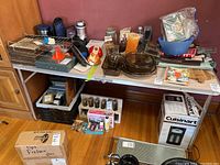 Full view of the retro folding aluminum table with various household items on top and below, illustrating no contents included in sale.