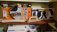 Photo of Black & Decker Mouse sander/polisher in box, clamps in packaging, and wooden hand sander block on shelf.