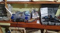 Overview of tools on shelf including Ryobi drill, Dremel tool, blue toolbox, and miscellaneous tools