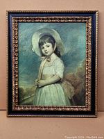 Framed antique print on canvas of a young girl in white dress and bonnet, front view.