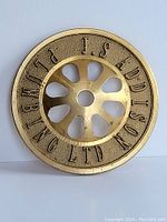 Top view of round brass plumbing strainer showing embossed company name and perforated center