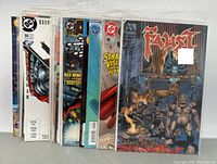 Photo showing comic books including Batman, Superman, Faust, Gigantor, Iron Soldier and others with colorful cover art in protective sleeves.