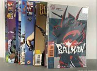 Photo showing a partial view of 8 comic books including Batman, Gigantor, Blaze of Glory, and Chaos! WWF