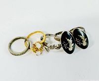 Three rings lined up showing the gold plated ring and two Siam sterling rings with black enamel insets