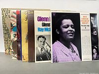 Eight vinyl records stacked showing the variety of artists across jazz, rock, and pop genres.