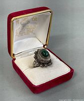 Ring displayed in red velvet box with satin lining, showing hallmark inside top lid.